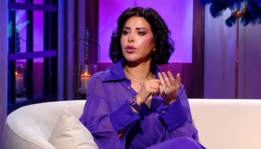 لقطة واضحة للفنانة شمس الكويتية أثناء مقابلة تلفزيونية تتحدث فيها عن استقلال المرأة وسط إضاءة بنفسجية داخل الاستوديو
